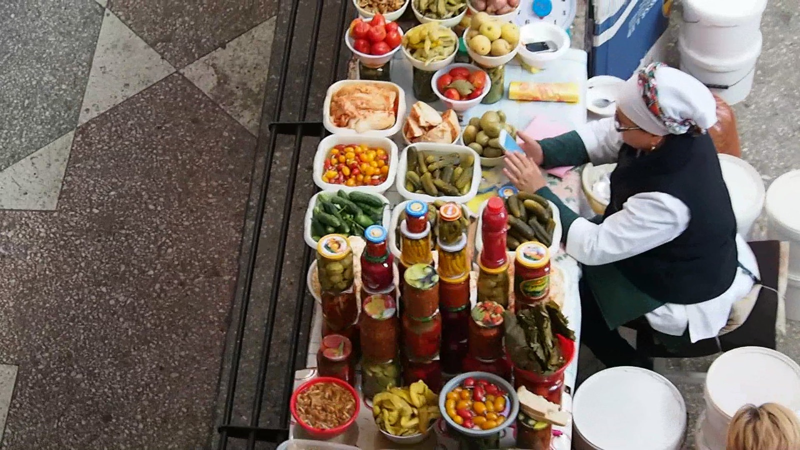 A market vendor in Kazakhstan using a smartphone — everyday connectivity exists alongside documented blocking and shutdowns
